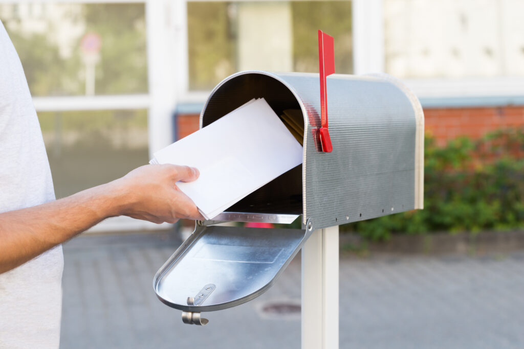eine Person beim leeren eines Briefkastens